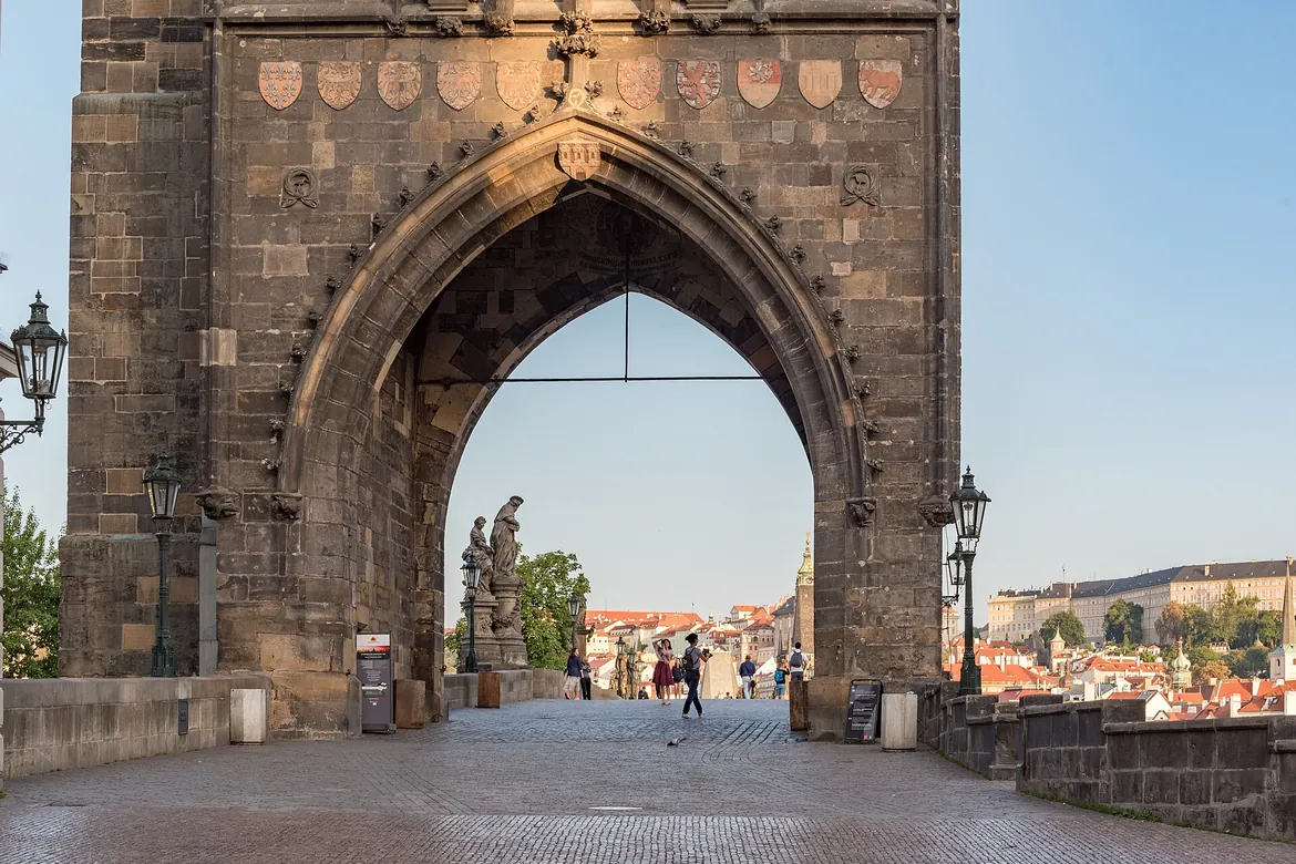 The pointed Gothic arch of the Old Town Bridge Tower, framing the start of Charles Bridge